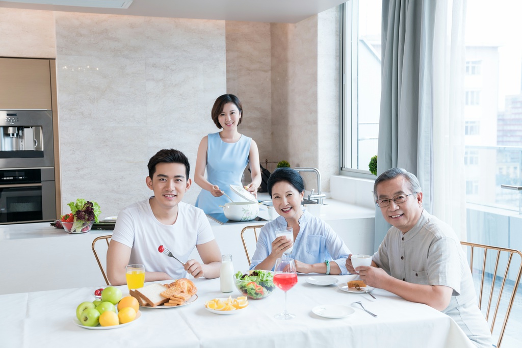 快乐的一家人在厨房吃早餐图片