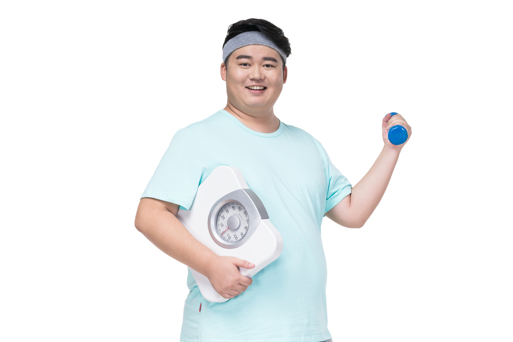 肥胖的年轻男子拿着体重秤健身