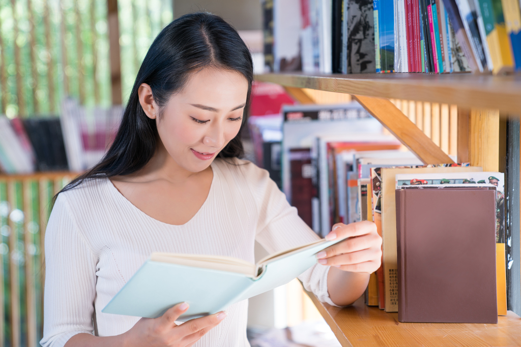 年轻女子在书店看书图片