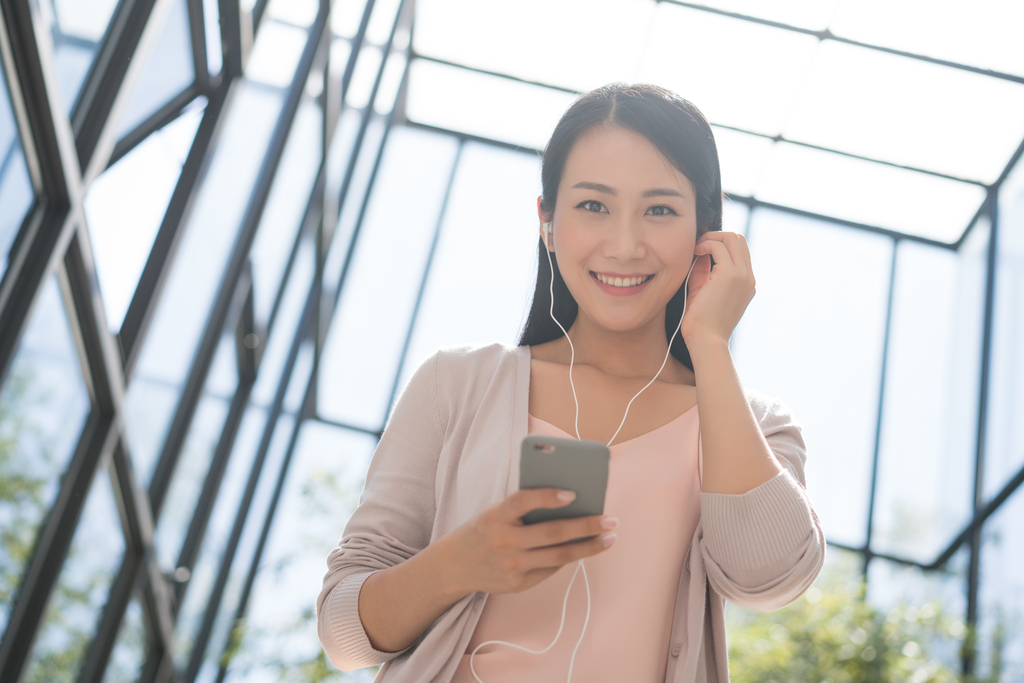 年轻女子拿着手机听音乐图片