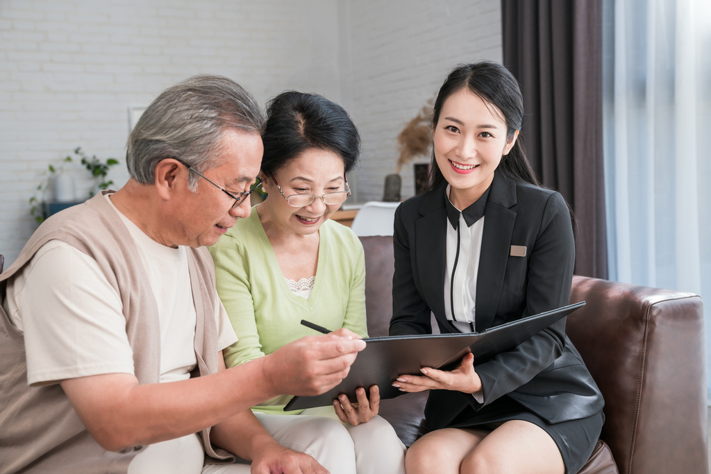 年轻女子向一对老夫妻介绍产品图片