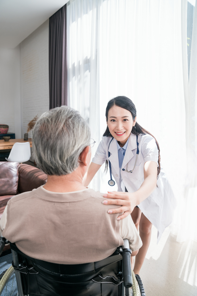 年轻的女医生在给老人做康复