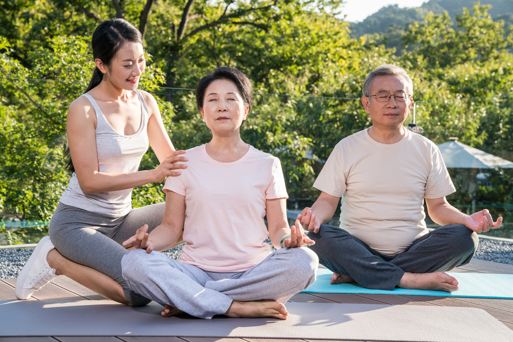 一个年轻女人在指导一对老年人锻炼身体图片