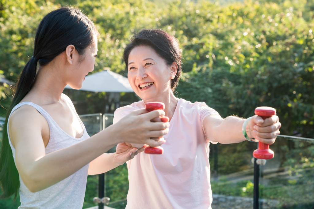 一个年轻女人在指导一个老年人锻炼身体图片