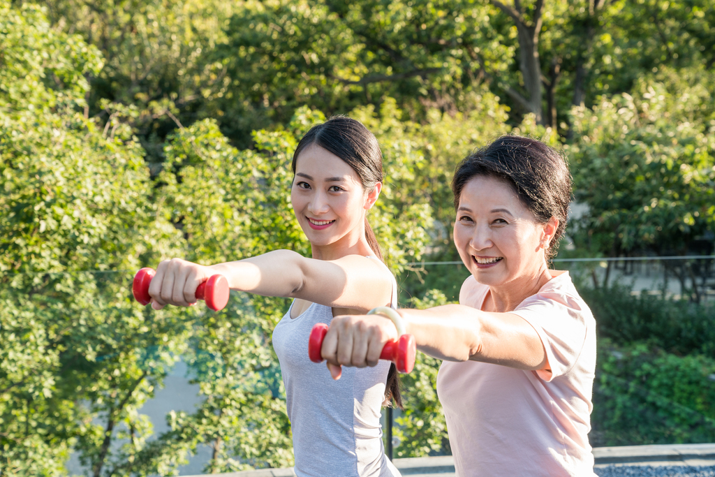 一个年轻女人在指导一个老年人锻炼身体