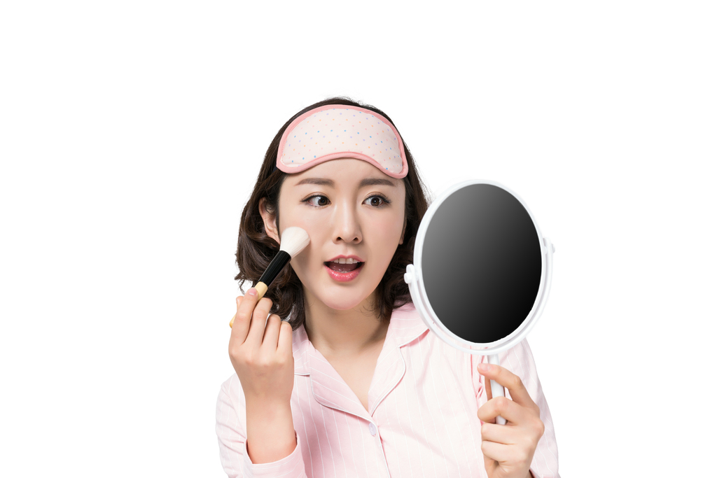 穿着睡衣的年轻女子在化妆图片