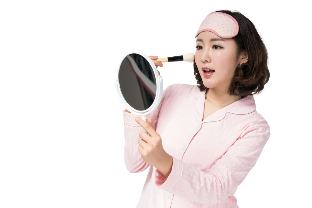 穿着睡衣的年轻女子在化妆图片