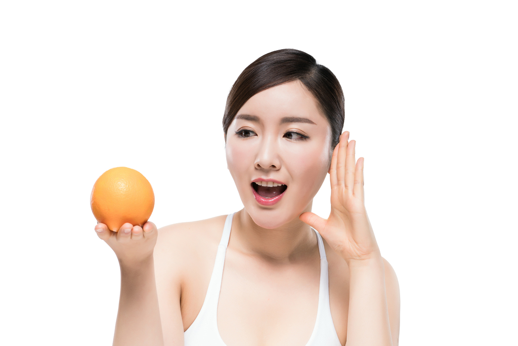 漂亮的年轻女子拿着橙子