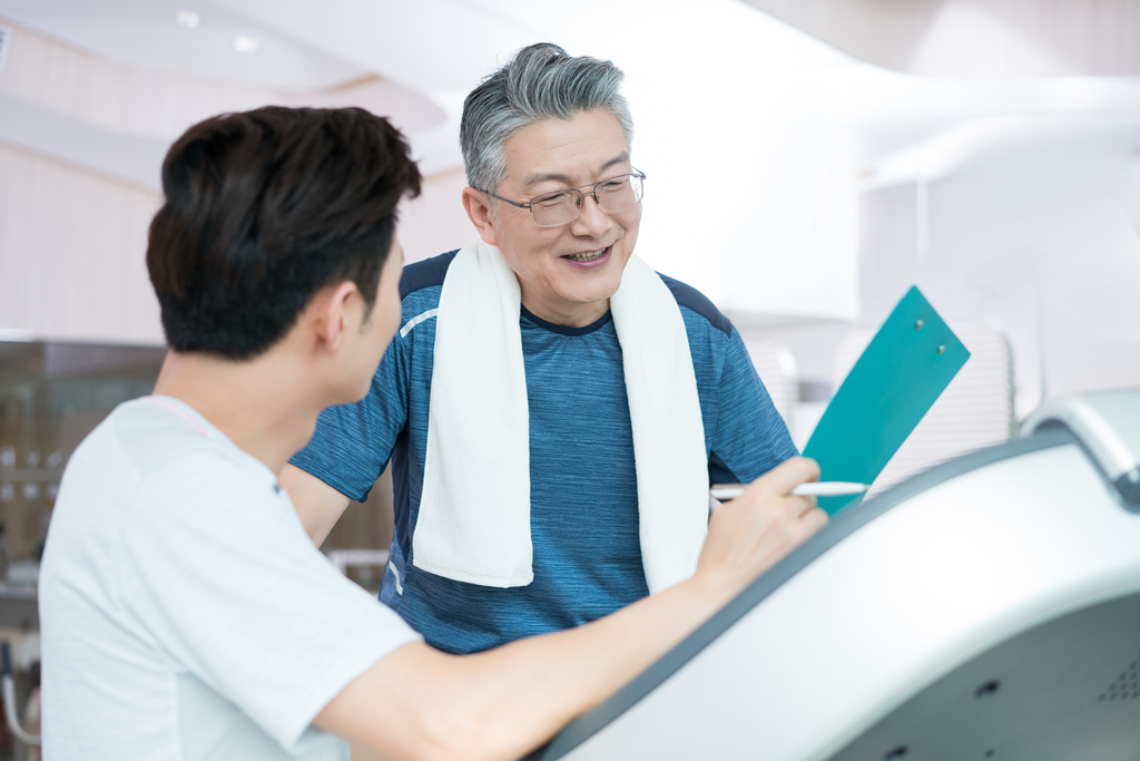 老年男子和年轻男子在健身房健身