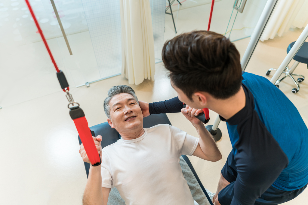 老年男子在私教的指导下健身图片