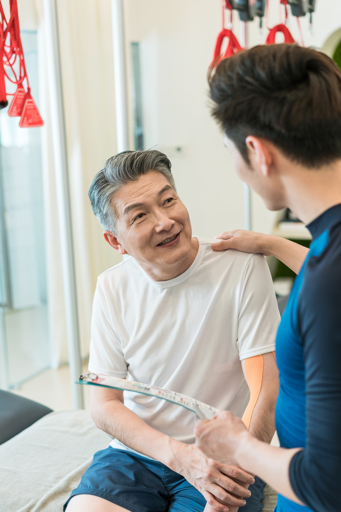 老年男子在私教的指导下健身图片