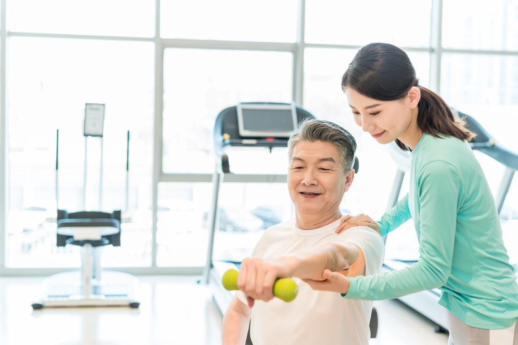 老年男子在私教的指导下健身图片