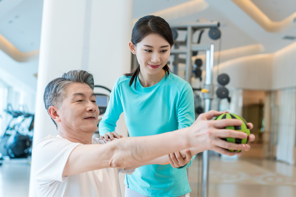 老年男子在私教的指导下健身图片