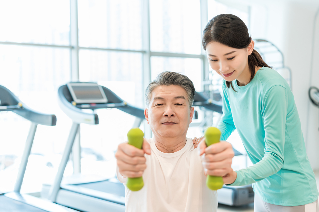 老年男子在私教的指导下健身图片