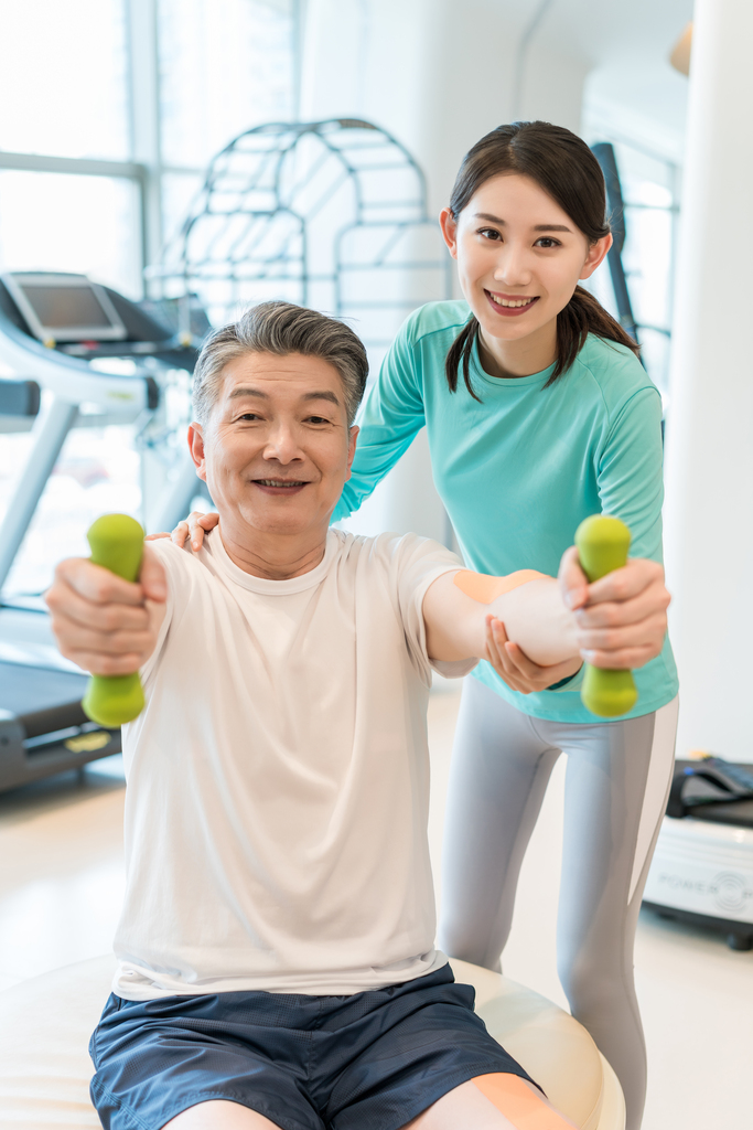 老年男子在私教的指导下健身图片