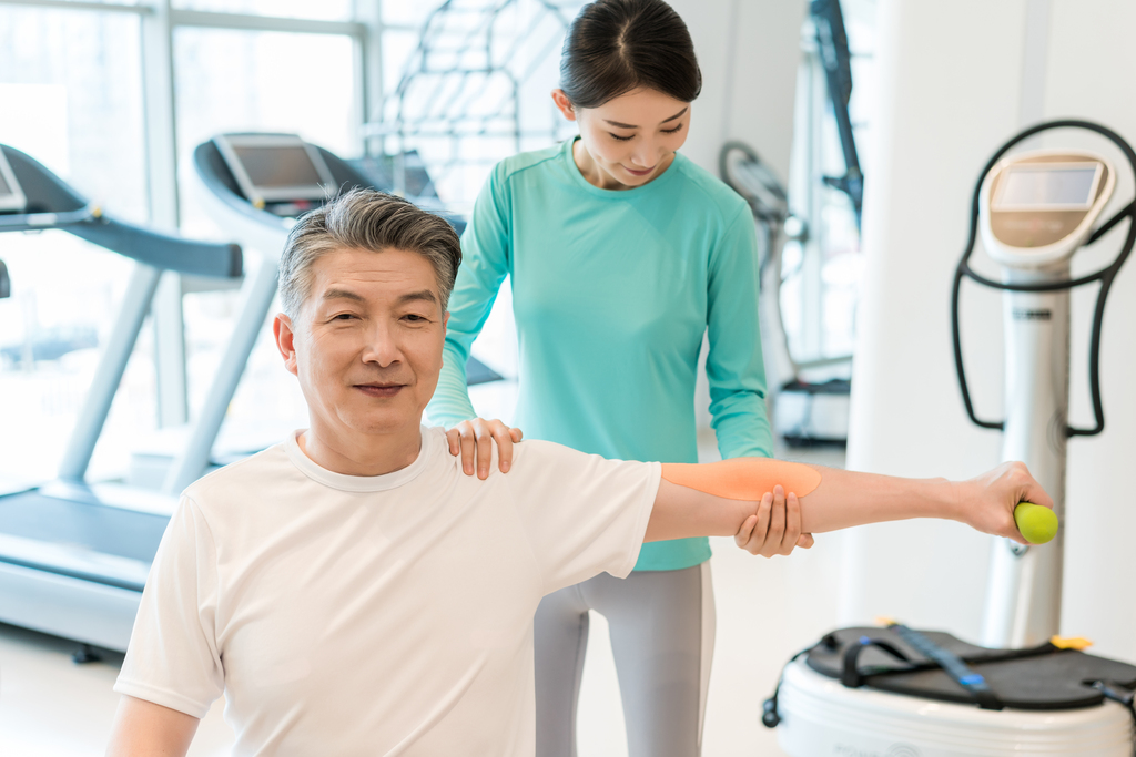 老年男子在私教的指导下健身图片