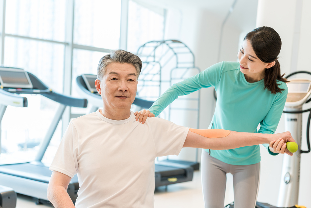 老年男子在私教的指导下健身图片