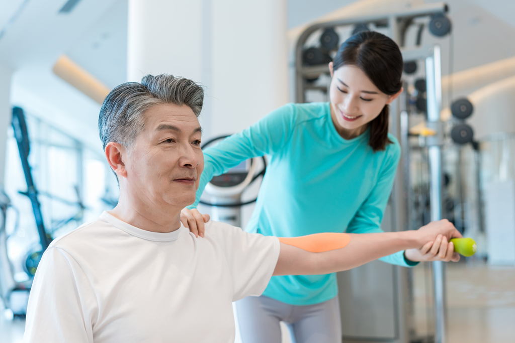 老年男子在私教的指导下健身图片