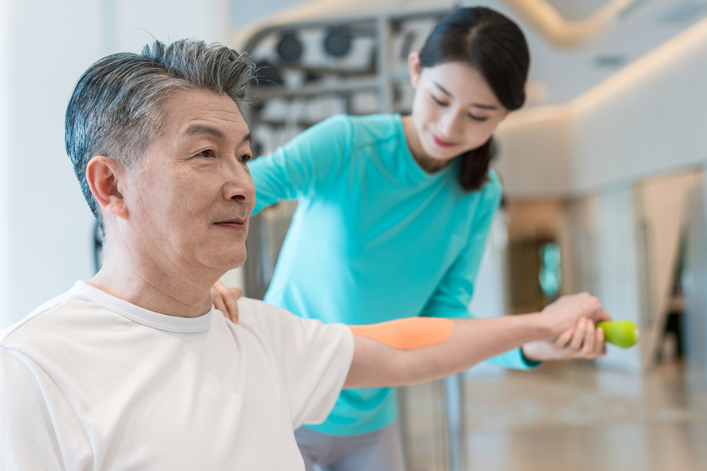 老年男子在私教的指导下健身图片