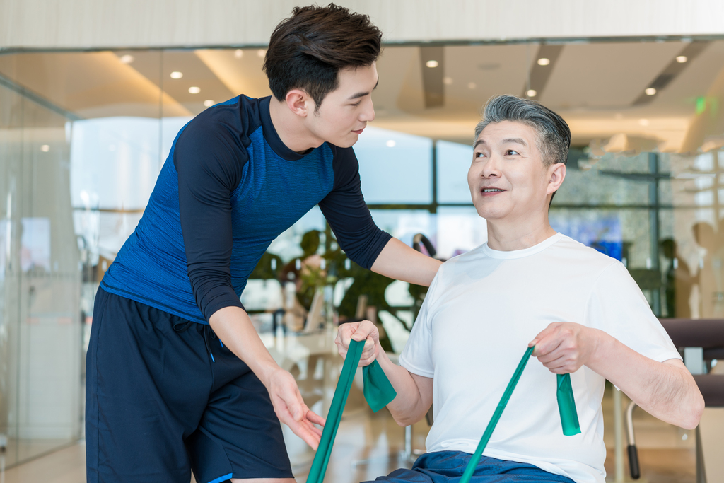 老年男子在私教的指导下健身图片