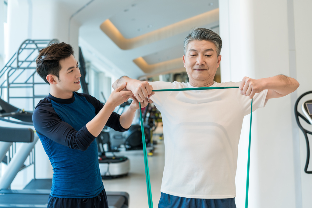 老年男子在私教的指导下健身图片