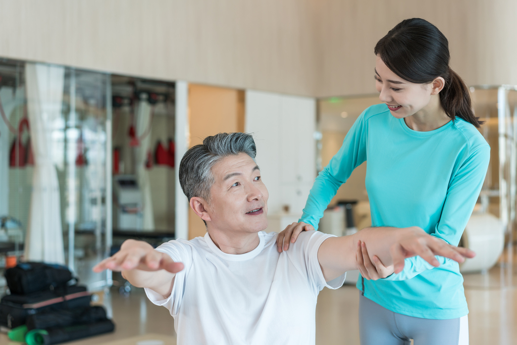 老年男子在私教的指导下健身图片