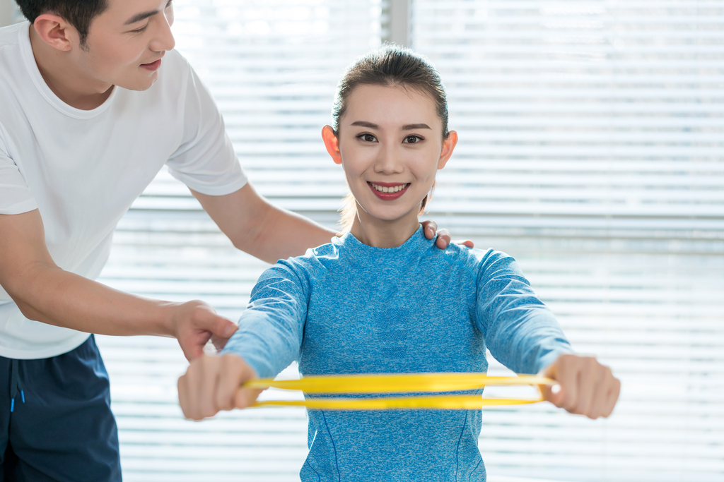 年轻女子在私教的指导下健身图片