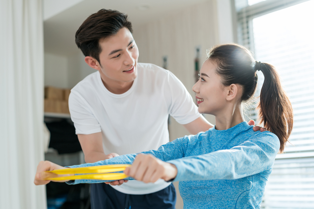 年轻女子在私教的指导下健身图片