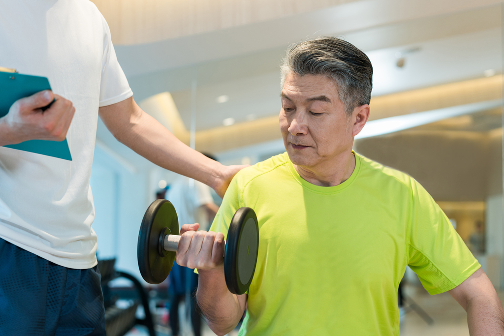 老年男子在私教的指导下健身图片