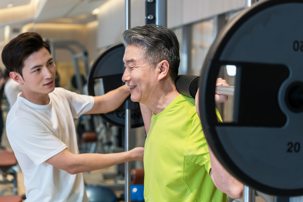 老年男子在私教的指导下健身图片