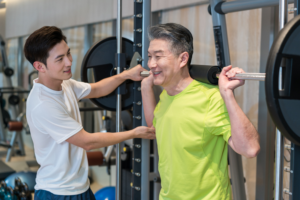 老年男子在私教的指导下健身