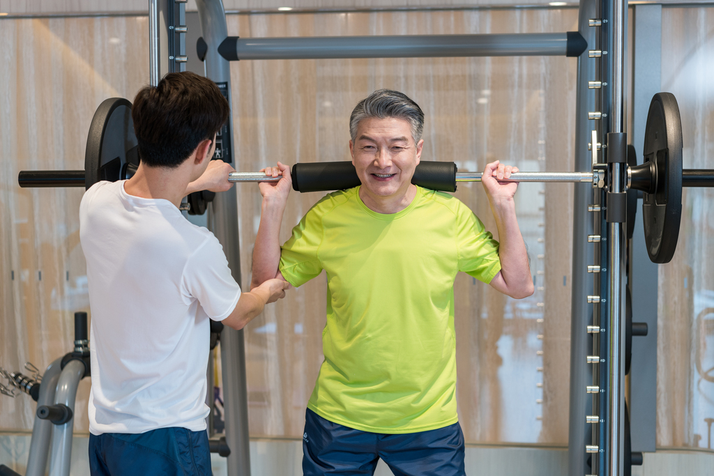 老年男子在私教的指导下健身图片