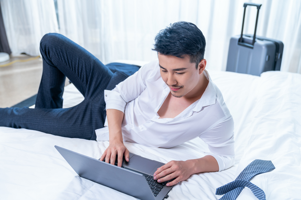 商务男士在宾馆使用笔记本电脑图片