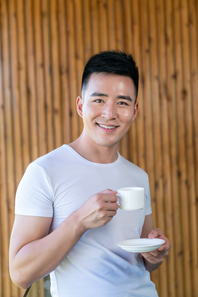 年轻男子在阳台喝咖啡