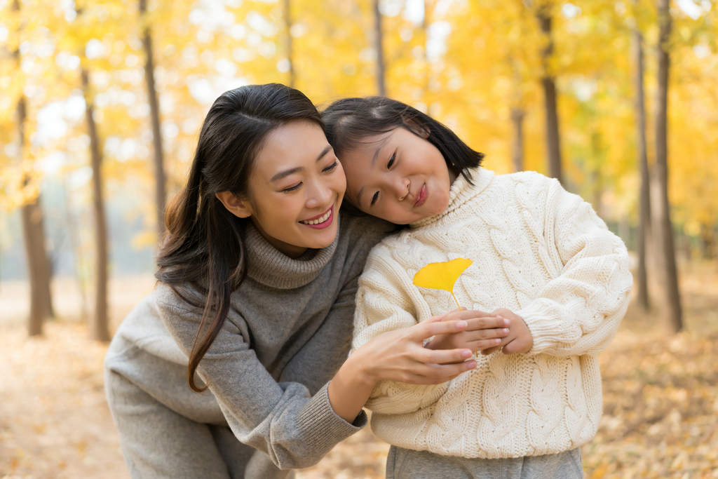 母女二人秋游漫步银杏林