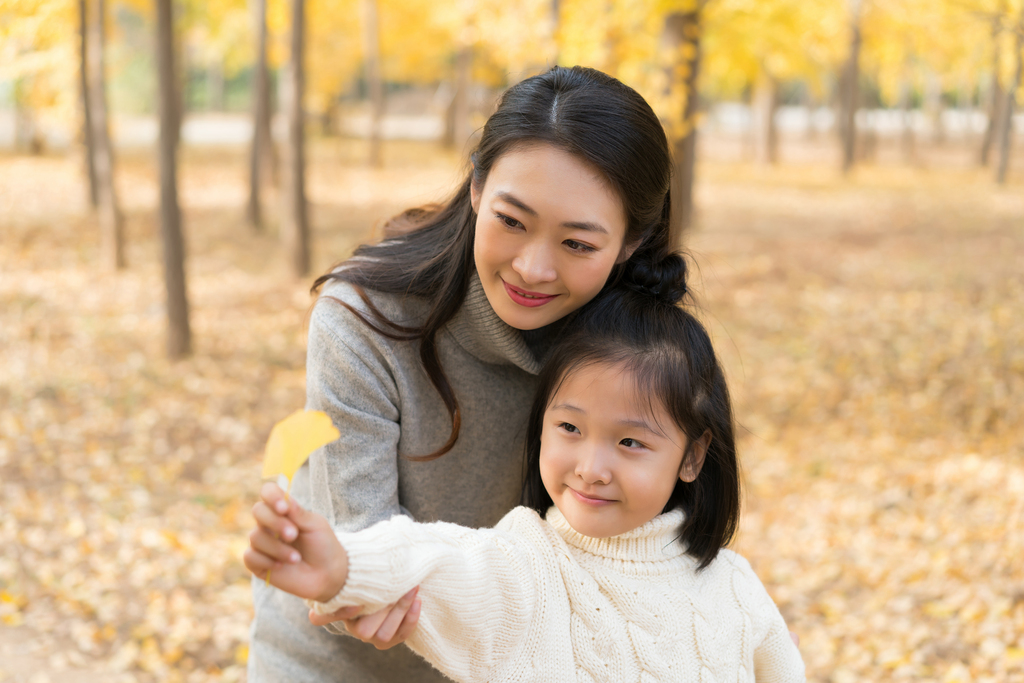 母女二人秋游漫步银杏林