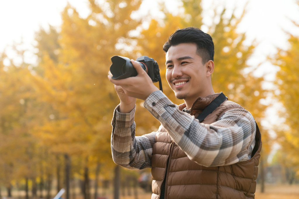 年轻男子秋游拍照图片