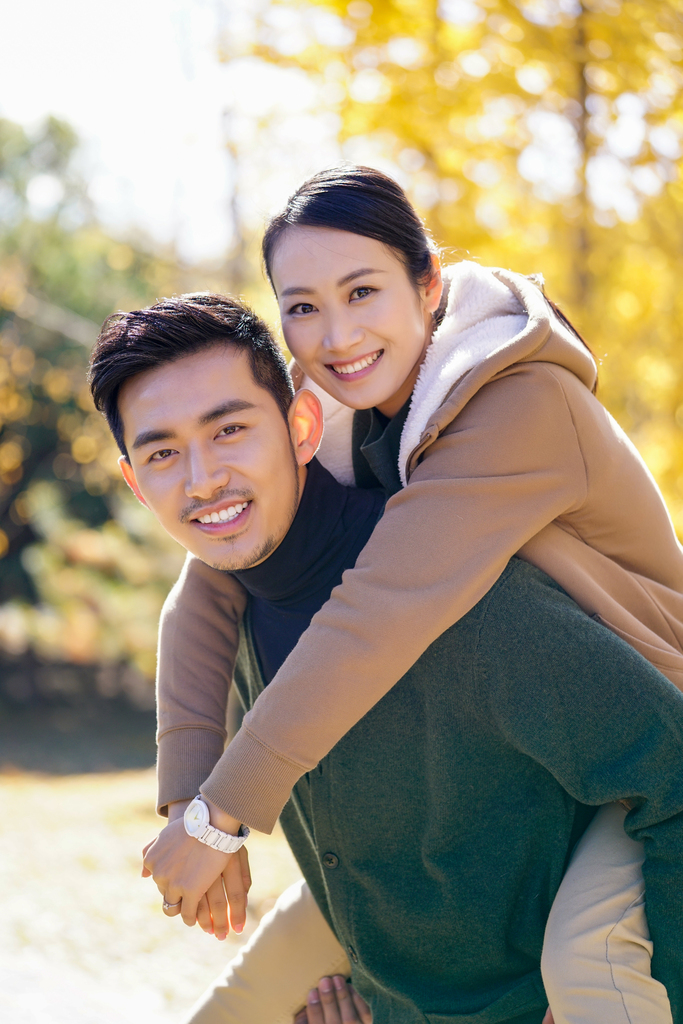年轻情侣秋游银杏林