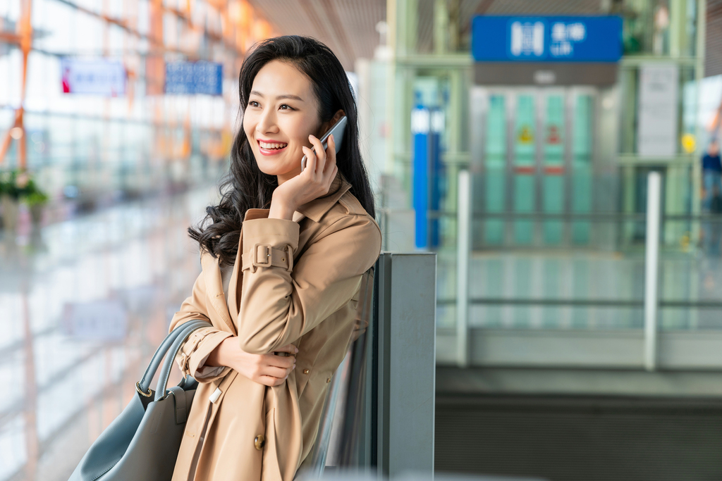 年轻女子在机场打电话图片