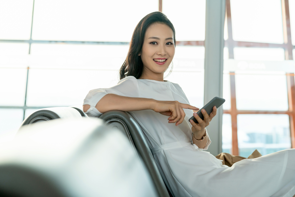 年轻女子在候机室使用手机图片