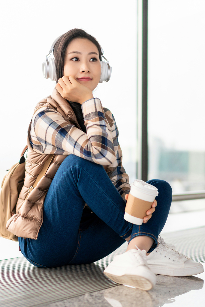 年轻女子在机场听音乐图片