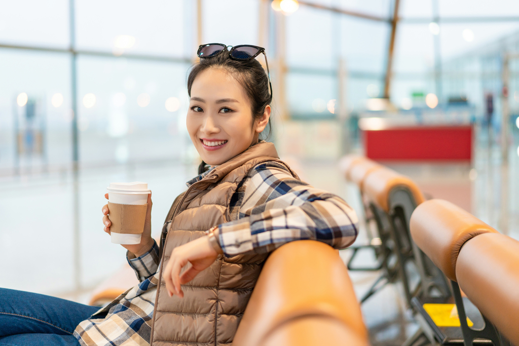 年轻女子在候机室喝咖啡图片