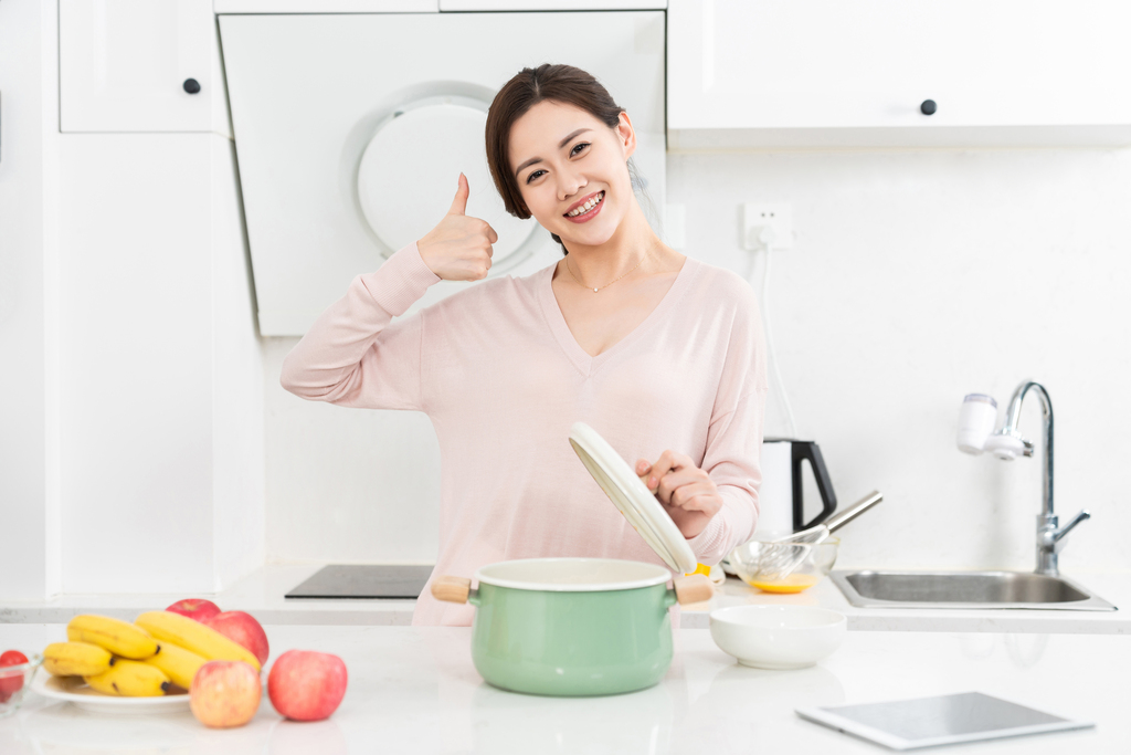 年轻女子在厨房做饭图片