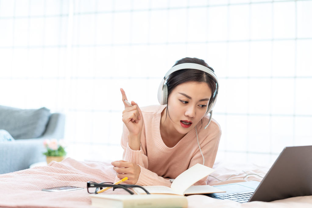 年轻女子在床上使用电脑图片