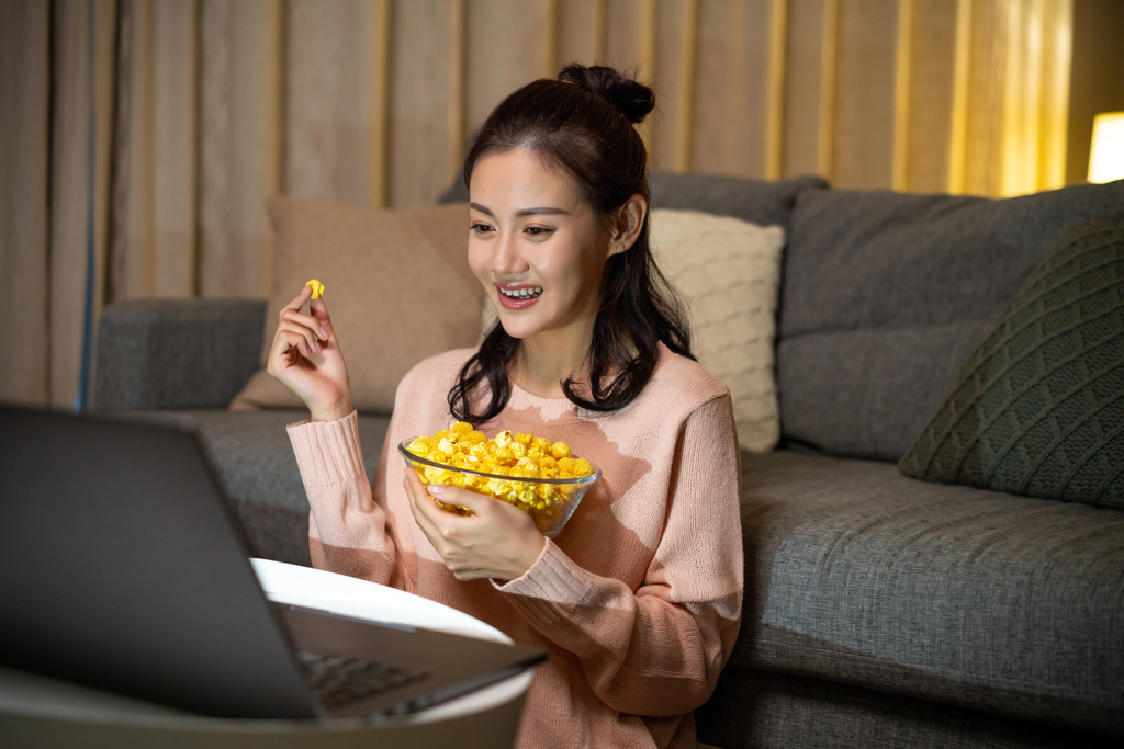 年轻女士在家吃使用电脑图片