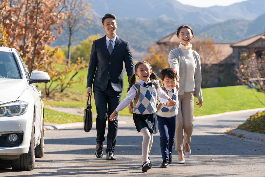 年轻夫妻送孩子去上学图片