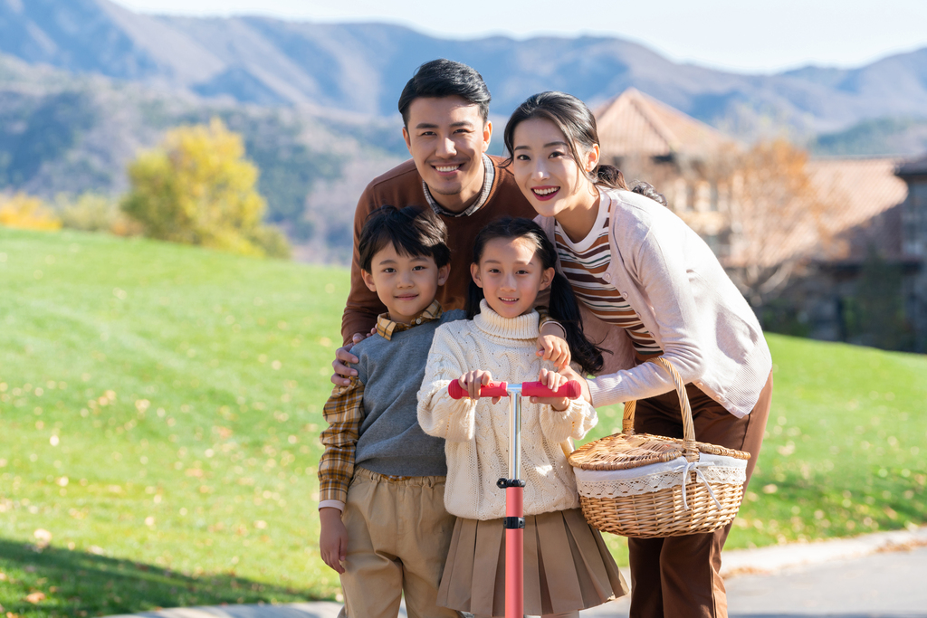 年轻夫妻带着孩子们在玩滑板车图片