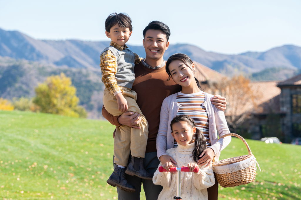 年轻夫妻带着孩子们在玩滑板车