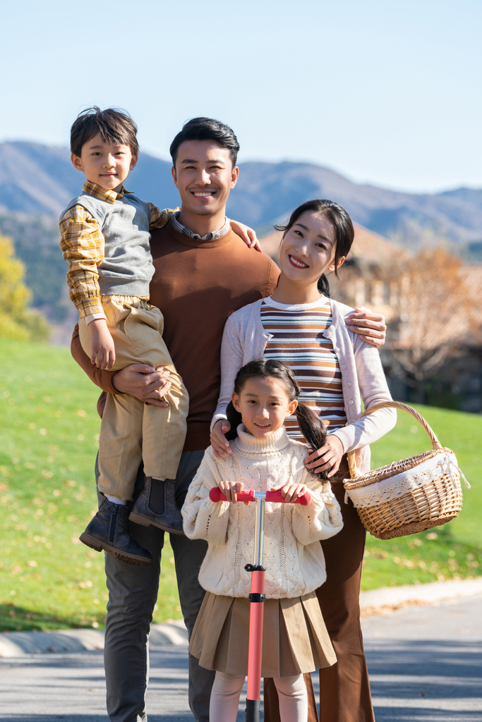 年轻夫妻带着孩子们在玩滑板车