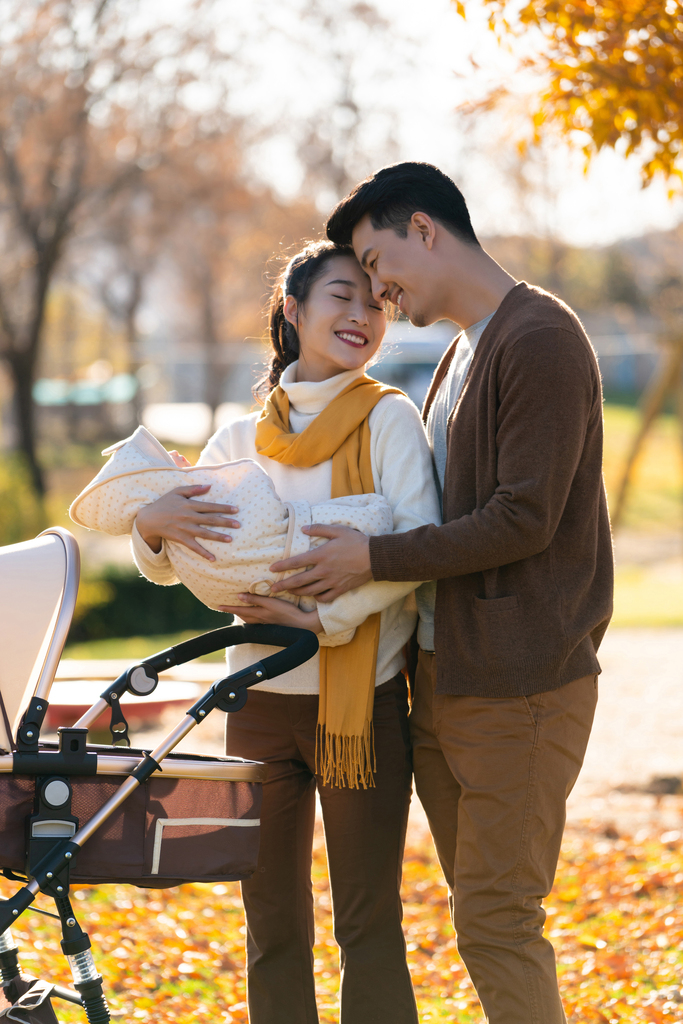 年轻夫妻推着婴儿车散步图片